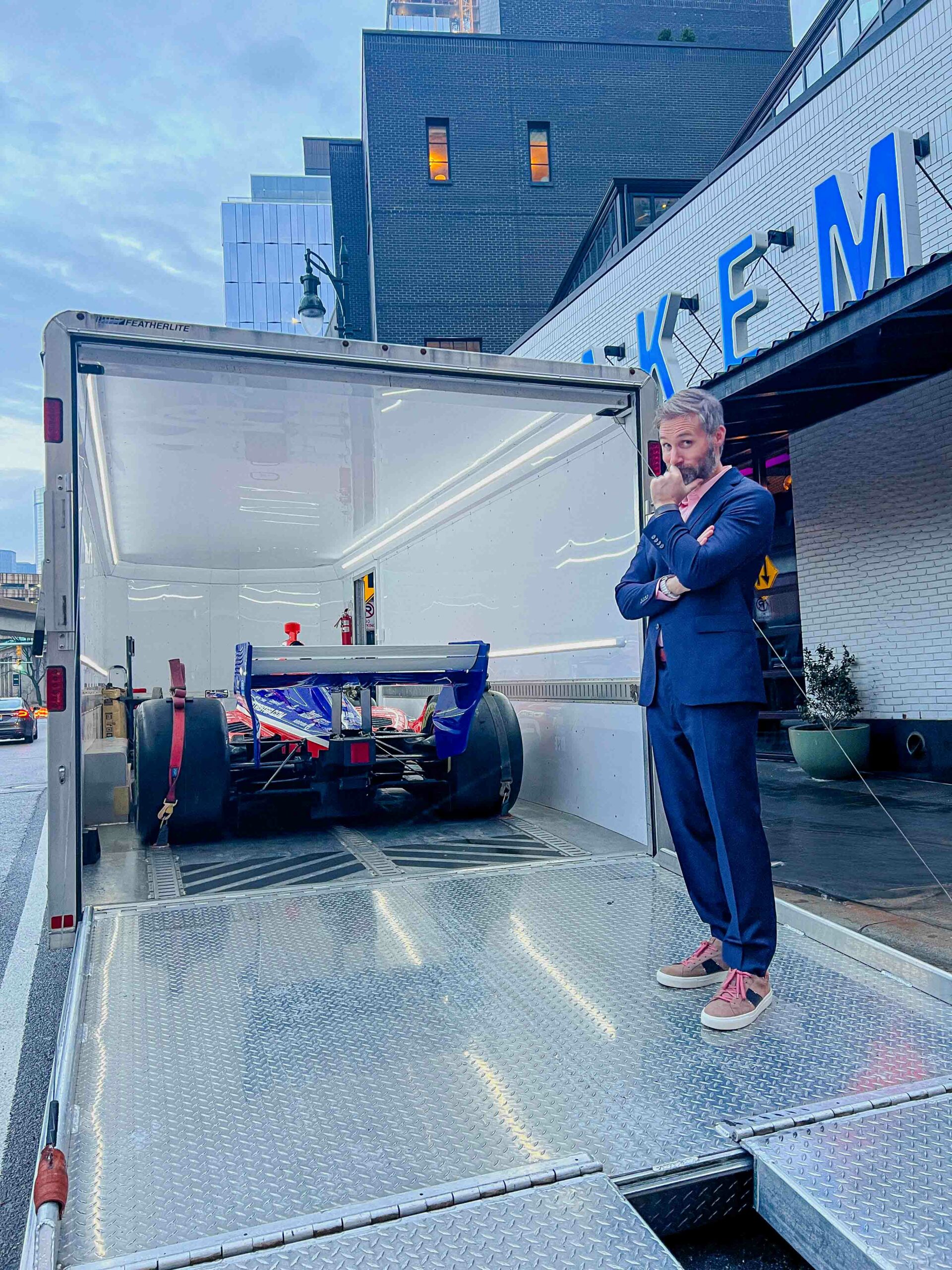 KARMA jack Founder Joel Sellentine standing near the 2024 Team Penske IndyCar as it gets ready to be shipped outside in Parker's Alley near the Brakeman in front of the Team Penske IndyCar