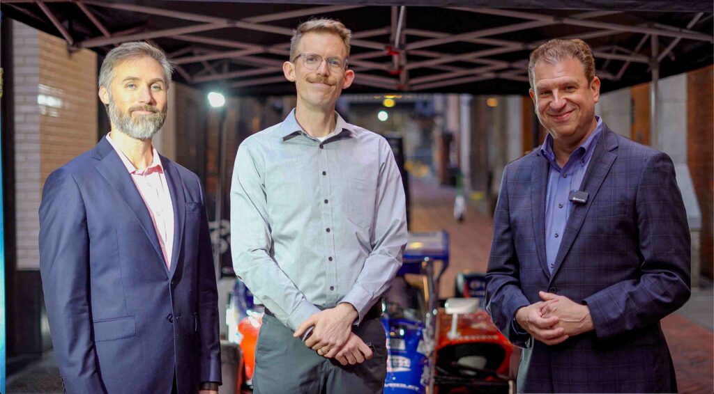 KARMA jack founder Joel Sellentine and Creative Director Jono Diener with Detroit Grand Prix Merrill Cain in Parker's Alley near the Brakeman in front of the Team Penske IndyCar